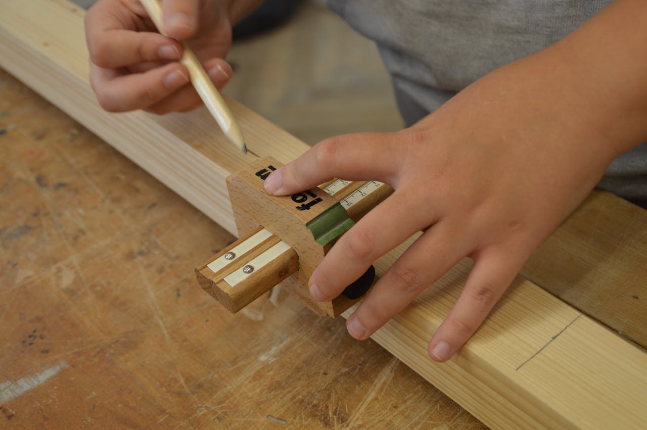Detailed close-up of hands using a measuring tool on wood. Ideal for crafting themes.
